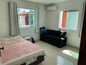 1 dormitorio con 1 cama, 1 sofá y 2 ventanas en Vila Bangalô, en São José da Coroa Grande