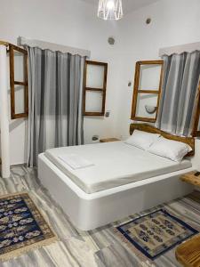 a bedroom with a large white bed in a room at George's Home Platy Gyalos in Kalymnos