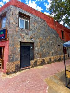 un edificio de piedra con una ventana y una puerta en Departamentos Céntricos Cafayate en Cafayate