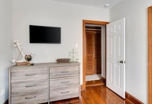 een slaapkamer met een dressoir en een televisie aan de muur bij Cozy Historic Family Home in the Heart of Richmond in Richmond