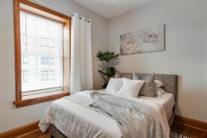 a bedroom with a bed with white sheets and a window at Cozy Historic Family Home in the Heart of Richmond in Richmond