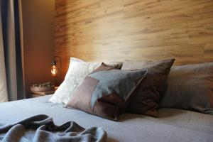 Schlafzimmer mit einem Kopfteil aus Holz und einem Bett mit Kissen in der Unterkunft L'Alberghetto in Trinità