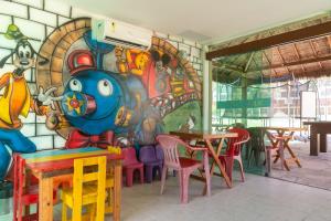 a restaurant with a mural on the wall w obiekcie Marulhos Suítes Resort Muro Alto Beira Mar por Brevelar w mieście Porto de Galinhas