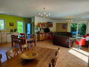 een keuken en een woonkamer met een tafel en een bank bij MAS DE LA COLOMBIERE in Blauvac