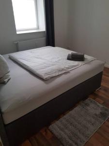 - un lit avec une couverture blanche dans l'établissement AKK3 Apartment Magdeburg Altstadt Zentral Balkon, à Magdebourg