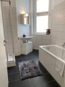 La salle de bains blanche est pourvue d'une baignoire et d'un lavabo. dans l'établissement AKK3 Apartment Magdeburg Altstadt Zentral Balkon, à Magdebourg