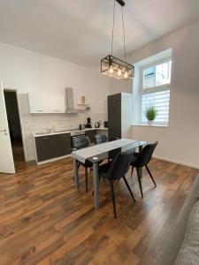 - une cuisine et une salle à manger avec une table et des chaises dans l'établissement AKK3 Apartment Magdeburg Altstadt Zentral Balkon, à Magdebourg