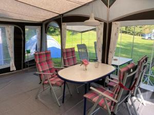 uma mesa e cadeiras sentadas dentro de uma tenda em Forrás camping em Magyarhertelend