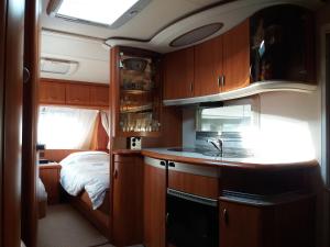 una cocina con fregadero y una cama en una habitación en Forrás camping en Magyarhertelend