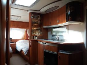 a kitchen with a sink and a bed in a room at Forrás camping in Magyarhertelend