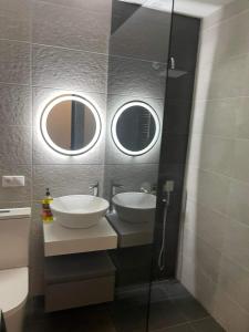 a bathroom with two sinks and two mirrors at Cozy apartment in Yerevan