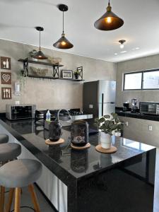 a kitchen with a large black counter with stools at Casa New York in Aquiraz