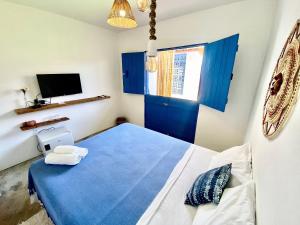 Un dormitorio con una puerta azul y una cama en Pousada Le Petit Suítes ER Hospedagens, en Porto de Pedras