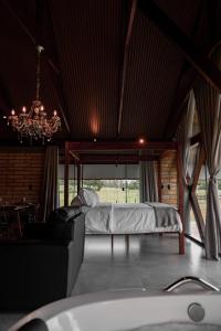 1 dormitorio con cama y lámpara de araña en Vicença Glamping, en Praia Grande