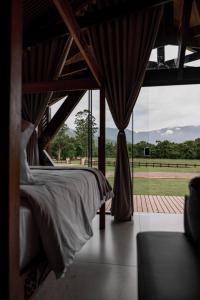 a bedroom with a bed and a large window at Vicença Glamping in Praia Grande