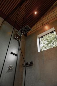 a shower in a bathroom with a window at Vicença Glamping in Praia Grande