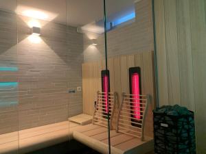 a glass shower with two red lights in a bathroom at Coeur Sablon in Brussels