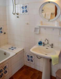 a bathroom with a sink and a tub and a mirror at Apartment in summer house with large balcony in Chorefto