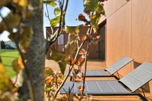 two lounge chairs on a deck next to a building at Hisa 1624 - Adults Only in Zgornja Kungota