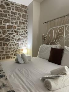 a white bed with two pillows and a brick wall at Marina Castellana Studios II in Halki