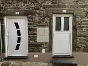two doors on the side of a stone building at Apartamentos Barbosa in Vila Nova de Foz Coa