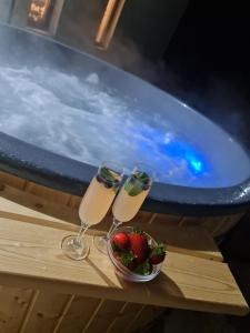 zwei Gläser Champagner und eine Schale Erdbeeren neben dem Pool in der Unterkunft Casa Daria 