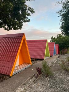 a row of colored houses sitting next to a sidewalk at Domaine de Meilly - M&P Concept Tipis Vue mer in Saint-Louis