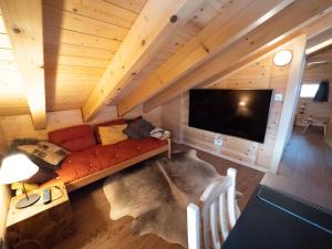 a living room with a couch and a flat screen tv at Chalet Chumma Galeriewohnung in Riederalp