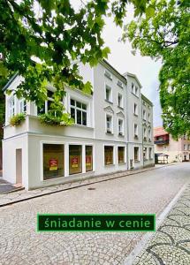 um grande edifício branco no lado de uma rua em CIENISTA 7 APARTMENTS em Lądek-Zdrój