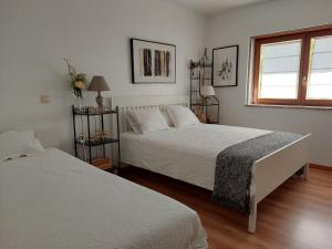 a white bedroom with two beds and a window at Cottage, Casa do Laranjal - Near Gerês in Geres +48 photos