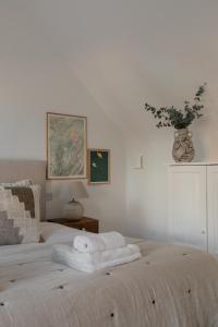 ein weißes Schlafzimmer mit einem Bett mit Handtüchern darauf in der Unterkunft Luxury Eton Cottage-Design Led in Eton
