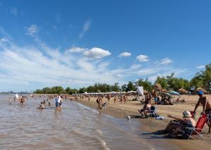 un grupo de personas en la playa en una playa en CASA MUY COMODA A METROS DEL SANTUARIO Y ECOPARQUE en San Nicolás de los Arroyos