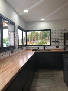 eine Küche mit einer Holztreppe und Fenstern in der Unterkunft CASA ALQUILER PINAMAR in Pinamar