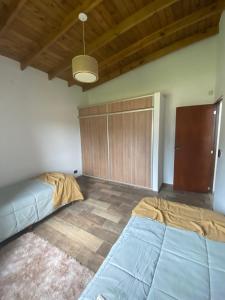 1 Schlafzimmer mit 2 Betten und Holzdecke in der Unterkunft CASA ALQUILER PINAMAR in Pinamar
