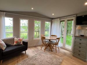 a living room with a table and a couch at Log Studio near Le Manoir aux Quat’Saisons, Oxford in Great Milton