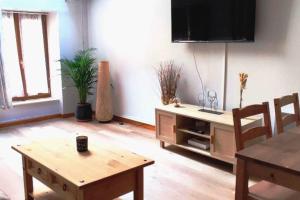 a living room with a table and a tv at Rare coin paisible pour une escapade cosy in Dijon