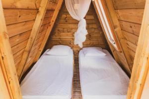 two beds in a log cabin bedroom with a roof at Domaine de Meilly - M&P Concept Tipis Vue mer in Saint-Louis