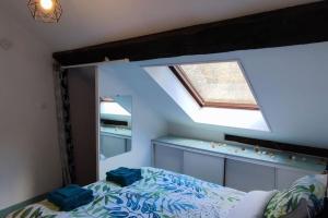 a bedroom with a bed and a skylight at Rare coin paisible pour une escapade cosy in Dijon +2 photos