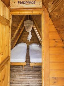 a room with two beds in a wooden cabin at Domaine de Meilly - M&P Concept Tipis Vue mer in Saint-Louis