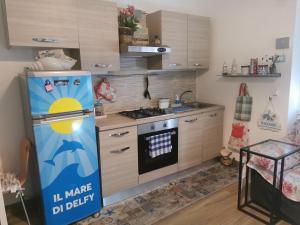 a kitchen with a refrigerator with a sign on it at Il Mare di Delfy in Lido di Ostia