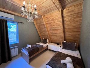 a room with two beds and a chandelier at Trigon Villa Family , HOT POOL ,SAUNA,JACUZZI in Gabala