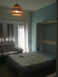 a bedroom with a bed and a couch and a lamp at Il Mare di Delfy in Lido di Ostia