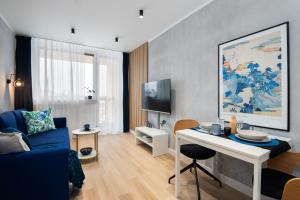 ein Wohnzimmer mit einem blauen Sofa und einem Tisch in der Unterkunft Apartament Gold - darmowy Parking, ścisłe centrum - by Kairos Apartments in Gliwice