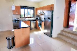 een keuken met een roestvrijstalen koelkast bij Villa Olivia Coral in Peyia