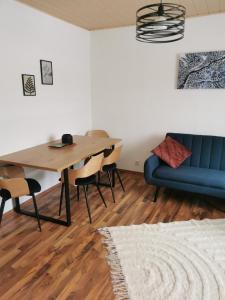 uma sala de jantar com um sofá azul e uma mesa em Riverside Appartements em Lieserbrücke