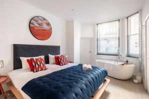 倫敦的住宿－Chelsea Posh apartment，一间卧室设有一张大床和一个浴缸