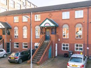 un edificio de ladrillo con una escalera que conduce a una puerta en Belfast City Apartment, en Belfast