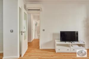 カディスにあるDulce Arbolí Little Apartmentsの白いキャビネット上のテレビ付きのリビングルーム
