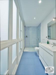 La salle de bains est pourvue d'un lavabo blanc et de toilettes. dans l'établissement Dulce Arbolí Little Apartments, à Cadix