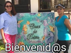 duas mulheres ao lado de um cartaz com um bolo em Casa De Polita em San Andrés
